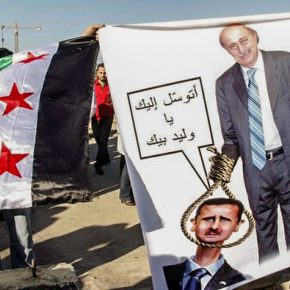 Demonstrators carry a Syrian opposition flag and a caricature depicting Lebanon's Druze leader Walid Jumblatt holding a noose around the neck of Syria's President Bashar al-Assad, during a protest in Martyrs Square in Beirut.
